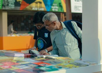 people browsing books at an outdoor marketplace