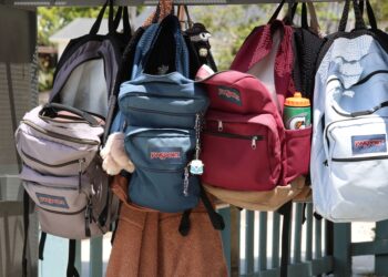 colorful backpacks hanging on hooks outdoors
