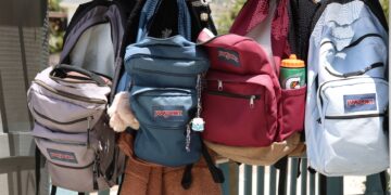 colorful backpacks hanging on hooks outdoors